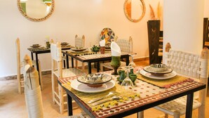 A dining area with tables set for a meal, chairs, and decorative items. - Riad Amra (Marrakech)