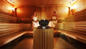 Una sauna con bancos de madera y una unidad de calefacción central.