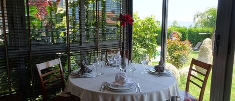 A dining table set for four with a white tablecloth, surrounded by wooden chairs.