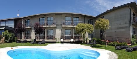 Una piscina al aire libre de temporada, tumbonas