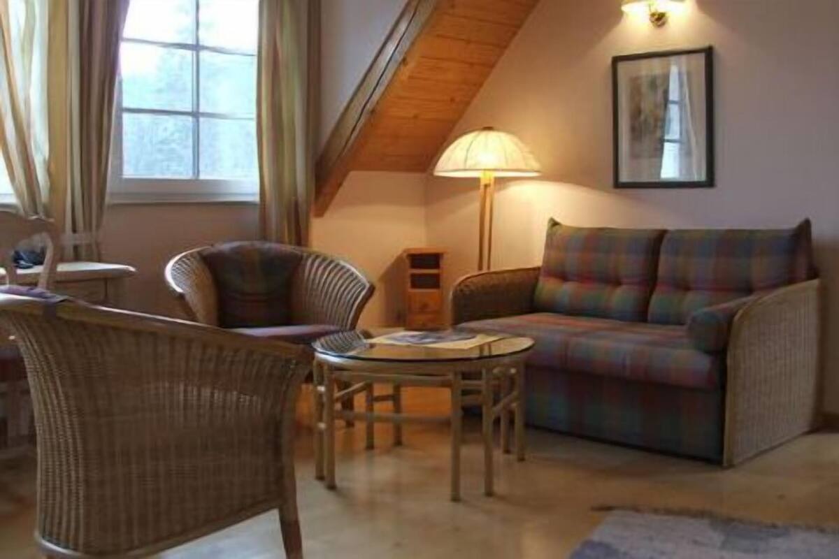A cozy living room with a sofa, armchair, and a small table.