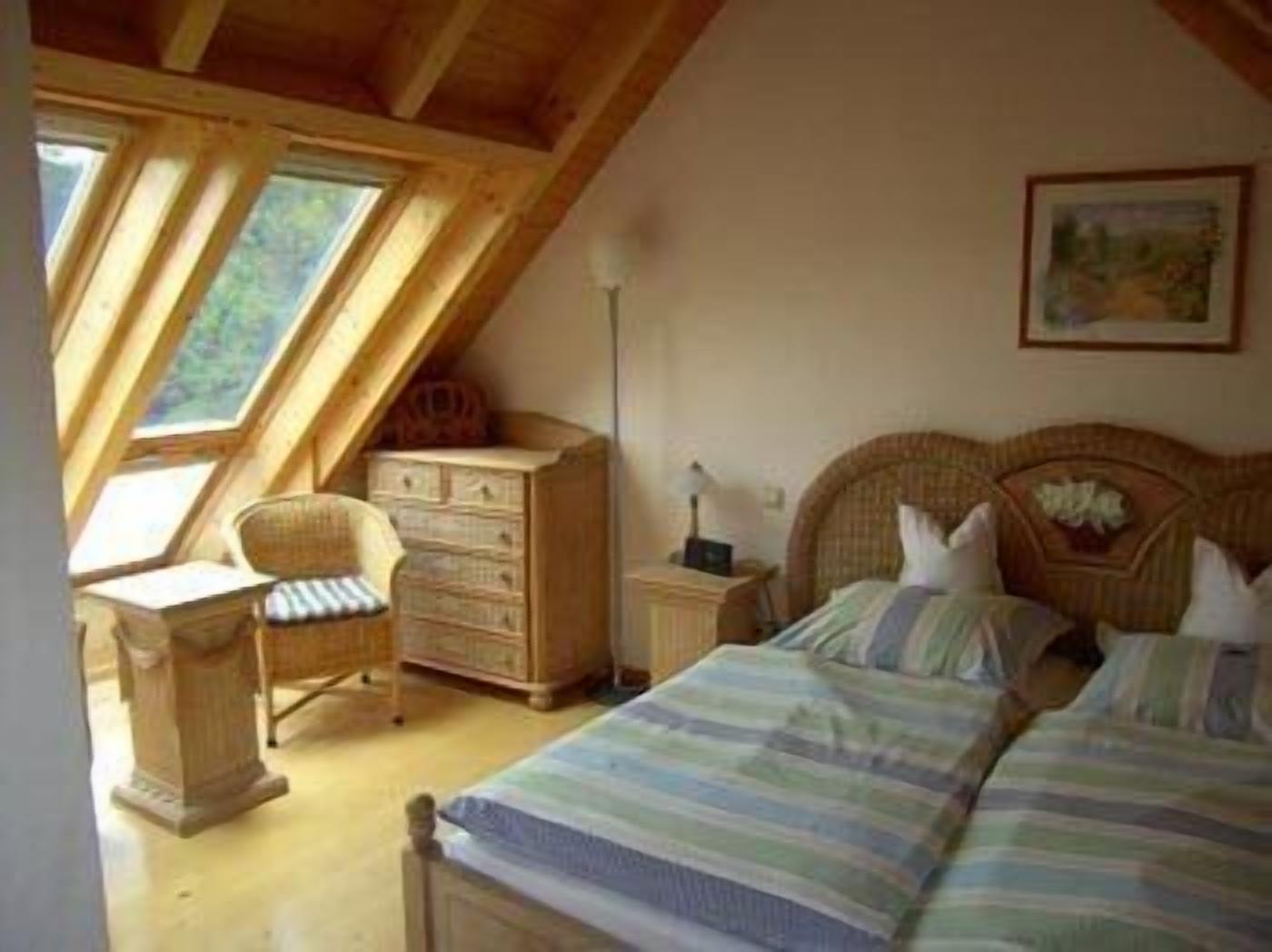 Un dormitorio con dos camas, un escritorio de madera, una silla, un aparador y un cuadro en la pared.
