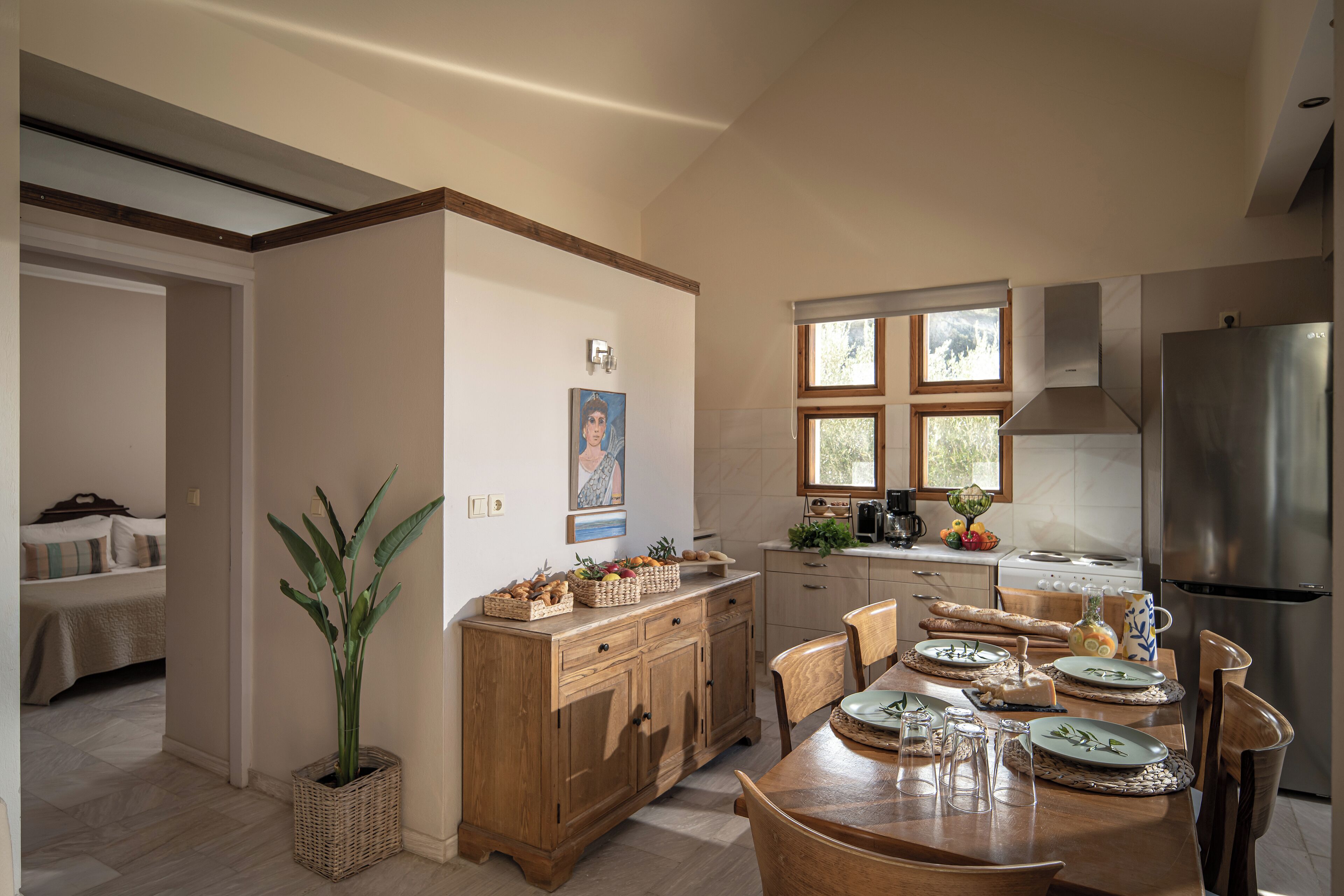 A modern kitchen with wooden cabinetry, a dining table set for four, and a large refrigerator.