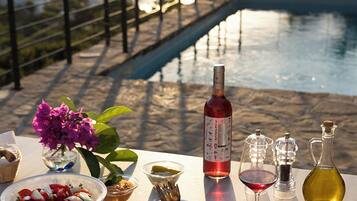 A dining table with a meal, wine, and a view of a bridge over water.