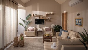 Un salon avec un canapé beige, deux fauteuils, une table basse et des objets de décoration.