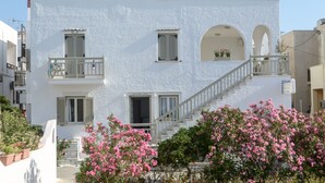 A white building with a balcony, a staircase, and a sign indicating it is a hotel. - Lygdamis Hotel (Naxos)