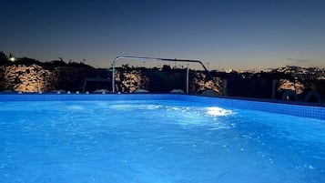 Una piscina al aire libre de temporada, sombrillas