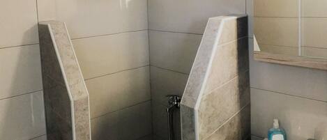 A bathroom with a shower, a toilet, and a sink.