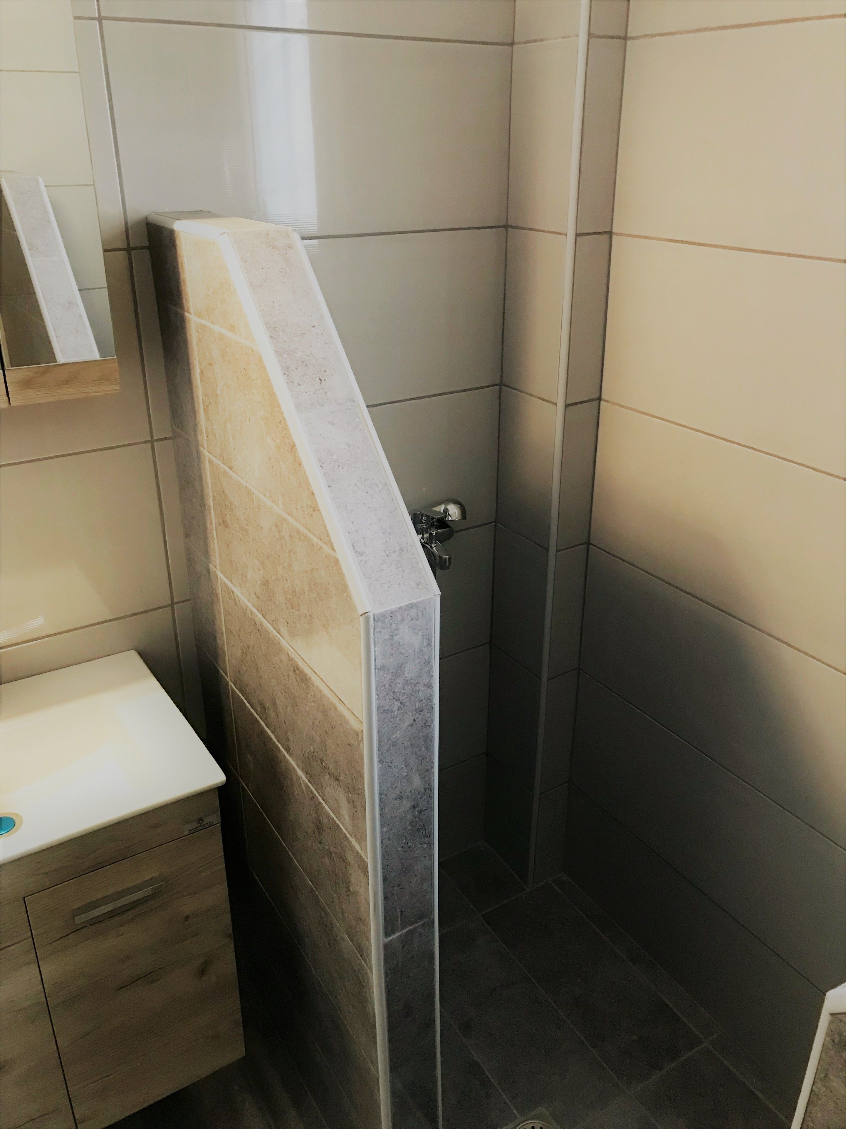 Ein Badezimmer mit Dusche, Toilette und Waschbecken.