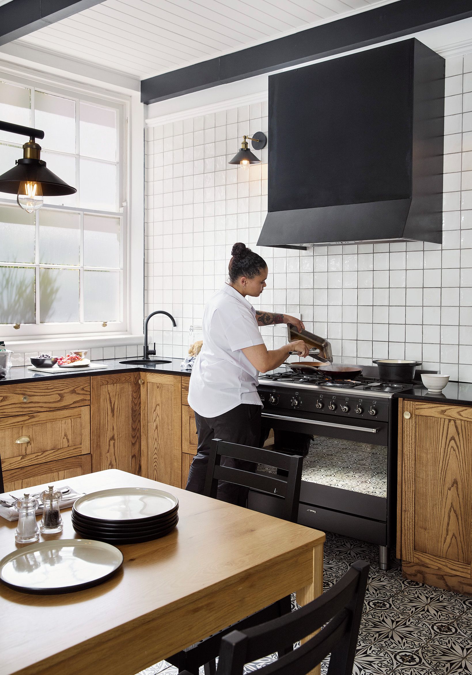 Une cuisine équipée d’une cuisinière, d’un évier et d’une fenêtre.