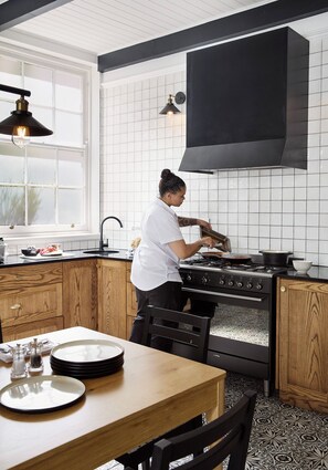 Een keuken met een fornuis, een spoelbak en een raam.
