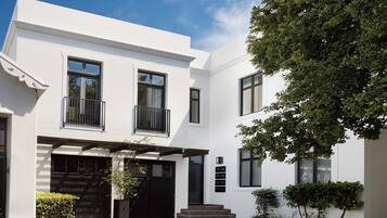 Un bâtiment moderne à deux étages, doté d’une façade blanche, de fenêtres noires et d’une porte de garage noire.