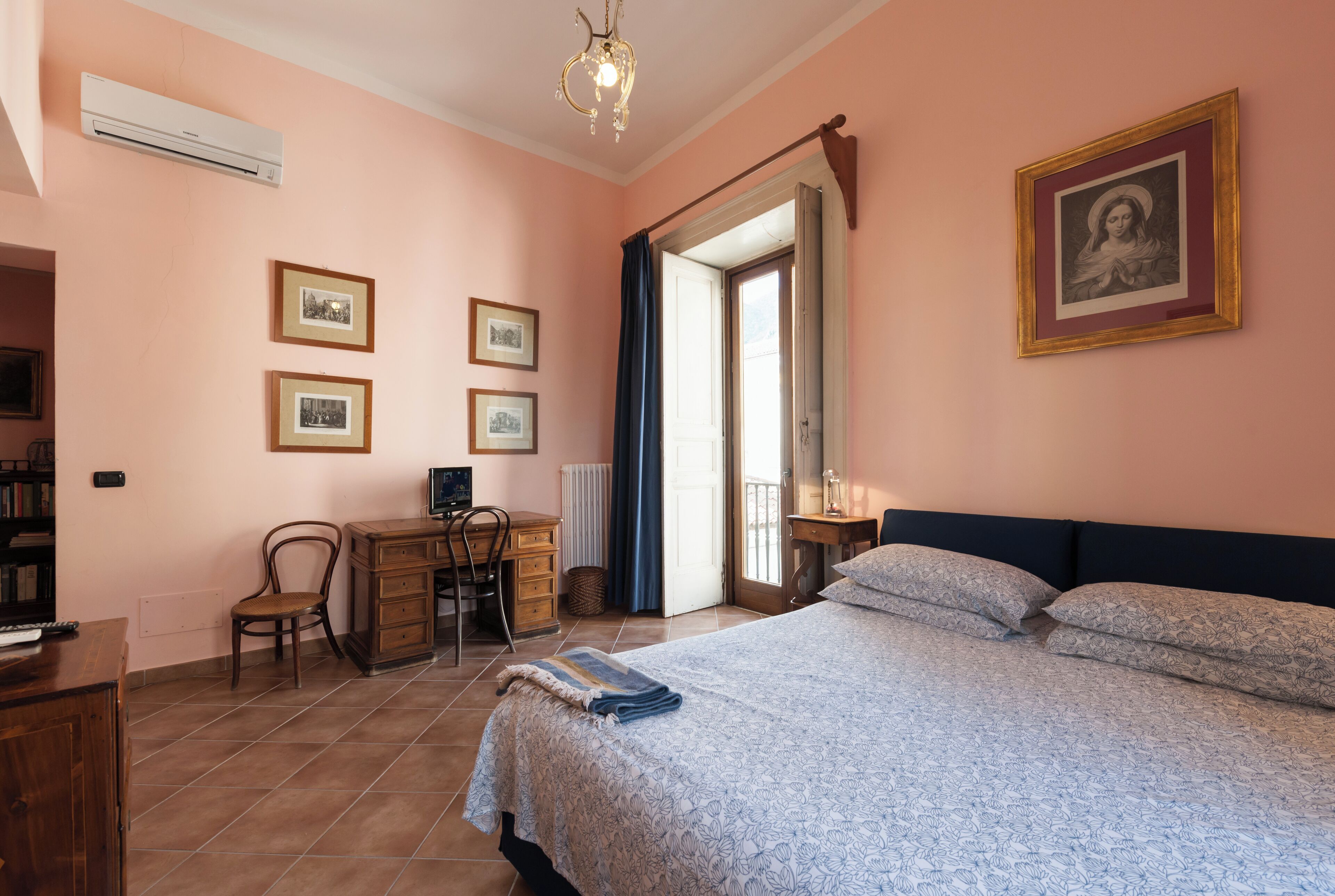 Un dormitorio con una cama, un escritorio, una silla y una estantería.