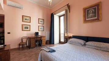 Un dormitorio con una cama, un escritorio, una silla y una estantería.
