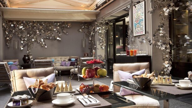 A cozy cafe with a tiered fruit display, comfortable seating, and a modern interior design. - Hôtel Les Jardins de La Villa (Paris)