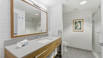 Uma casa de banho moderna com um espelho grande, duas pias, uma sanita e um chuveiro.