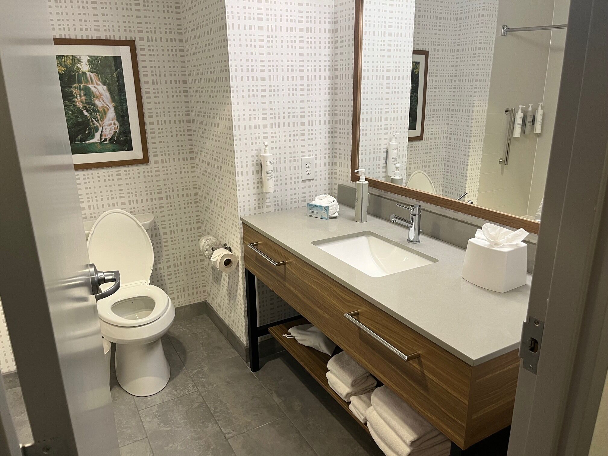 A modern bathroom with a toilet, sink, and vanity.