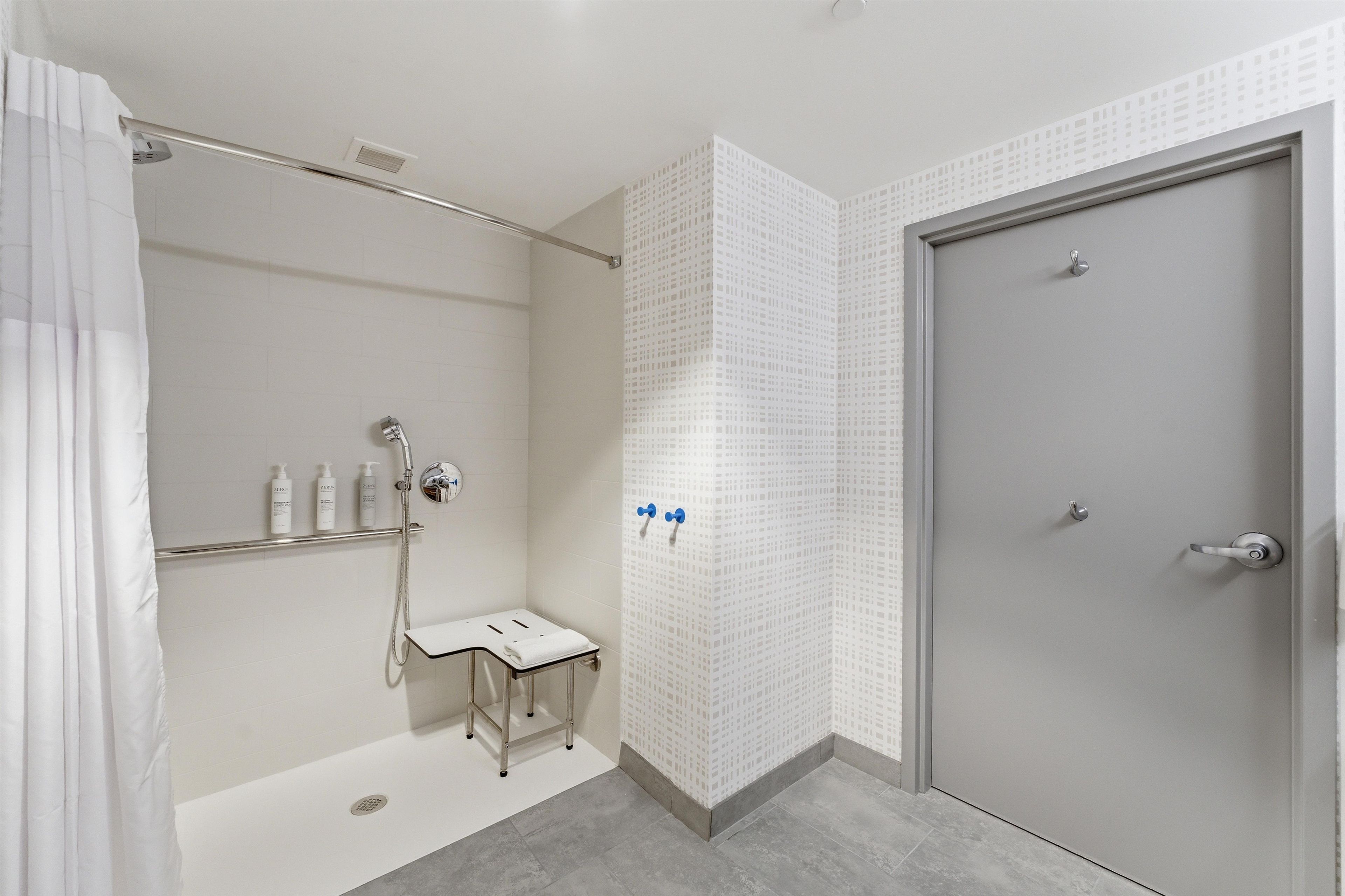 Un baño moderno con ducha, inodoro y puerta.