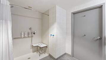 Un baño moderno con ducha, inodoro y puerta.
