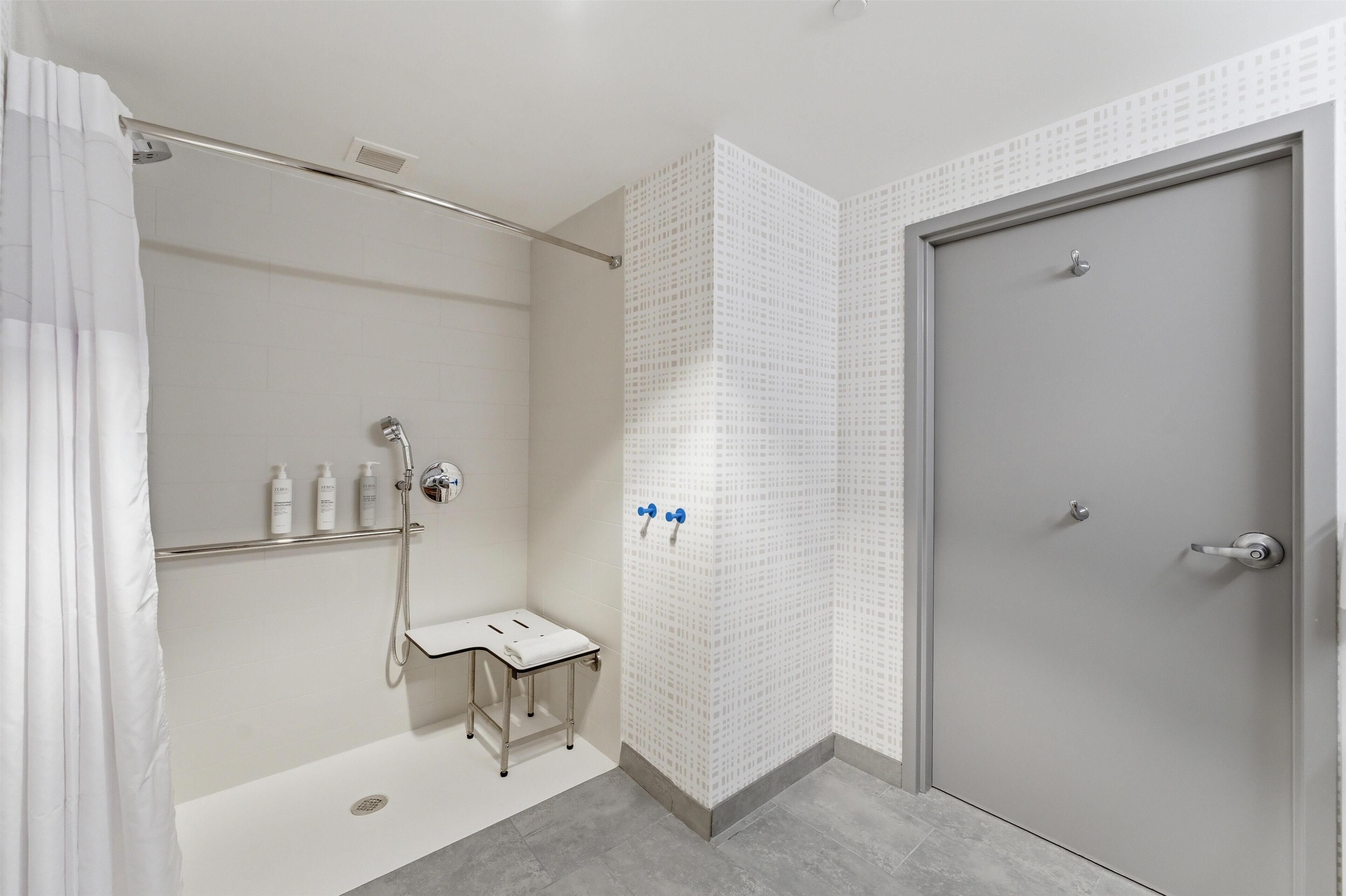 Ein modernes Badezimmer mit Dusche, Toilette und einer Tür.