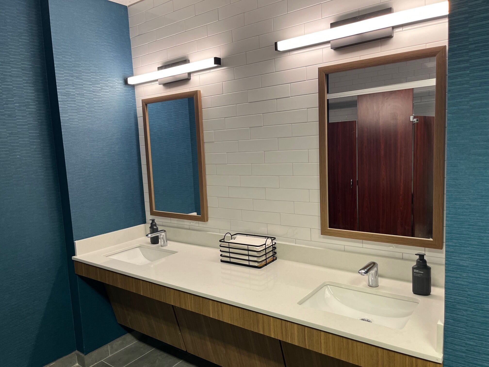 Un baño moderno con dos lavamanos, un espejo y un mueble de tocador de madera.