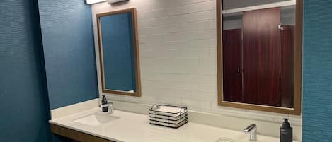 Un baño moderno con dos lavamanos, un espejo y un mueble de tocador de madera.