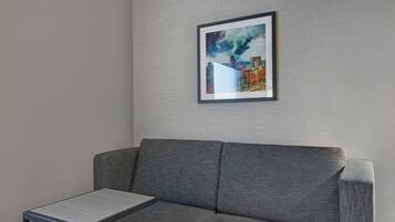 Un canapé gris, avec un tableau encadré accroché au mur juste au-dessus.