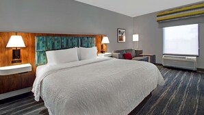 Habitación de hotel con una cama grande, dos lámparas de noche, un televisor y una ventana con vistas.