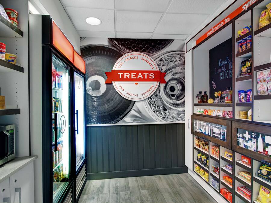 A snack section with a variety of treats, including chips and candies, and a refrigerator with beverages.