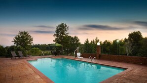A rectangular swimming pool with a tiled deck, surrounded by a brick wall and metal fencing. - La Quinta Inn & Suites by Wyndham Tupelo (Tupelo)