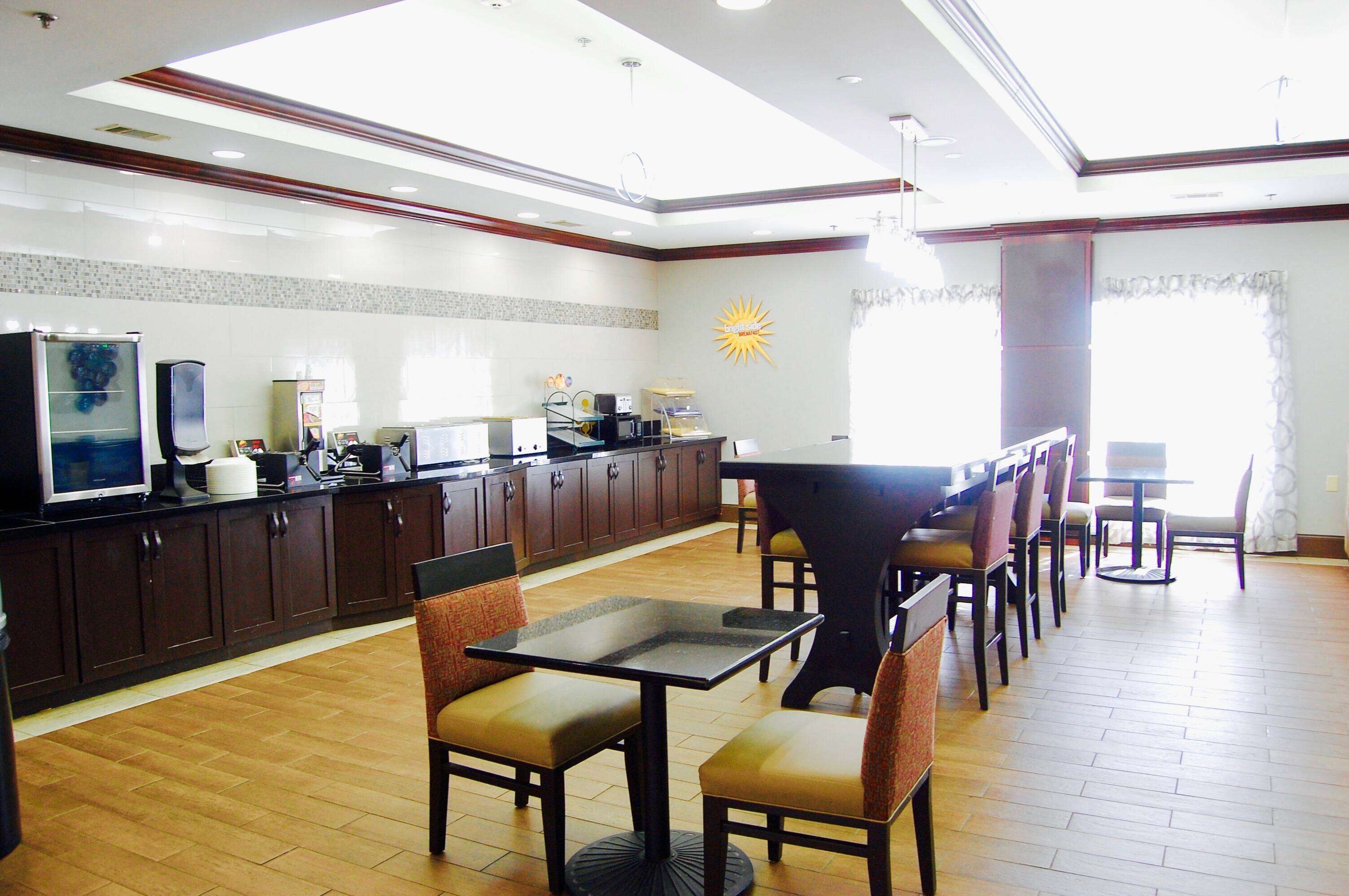 A spacious dining area with a long counter, multiple chairs, and a central table.