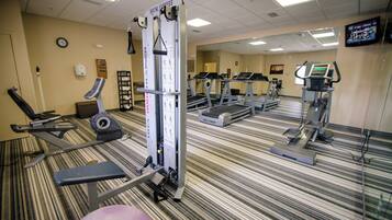 A hotel fitness center with treadmills, elliptical machines, and weight training equipment.