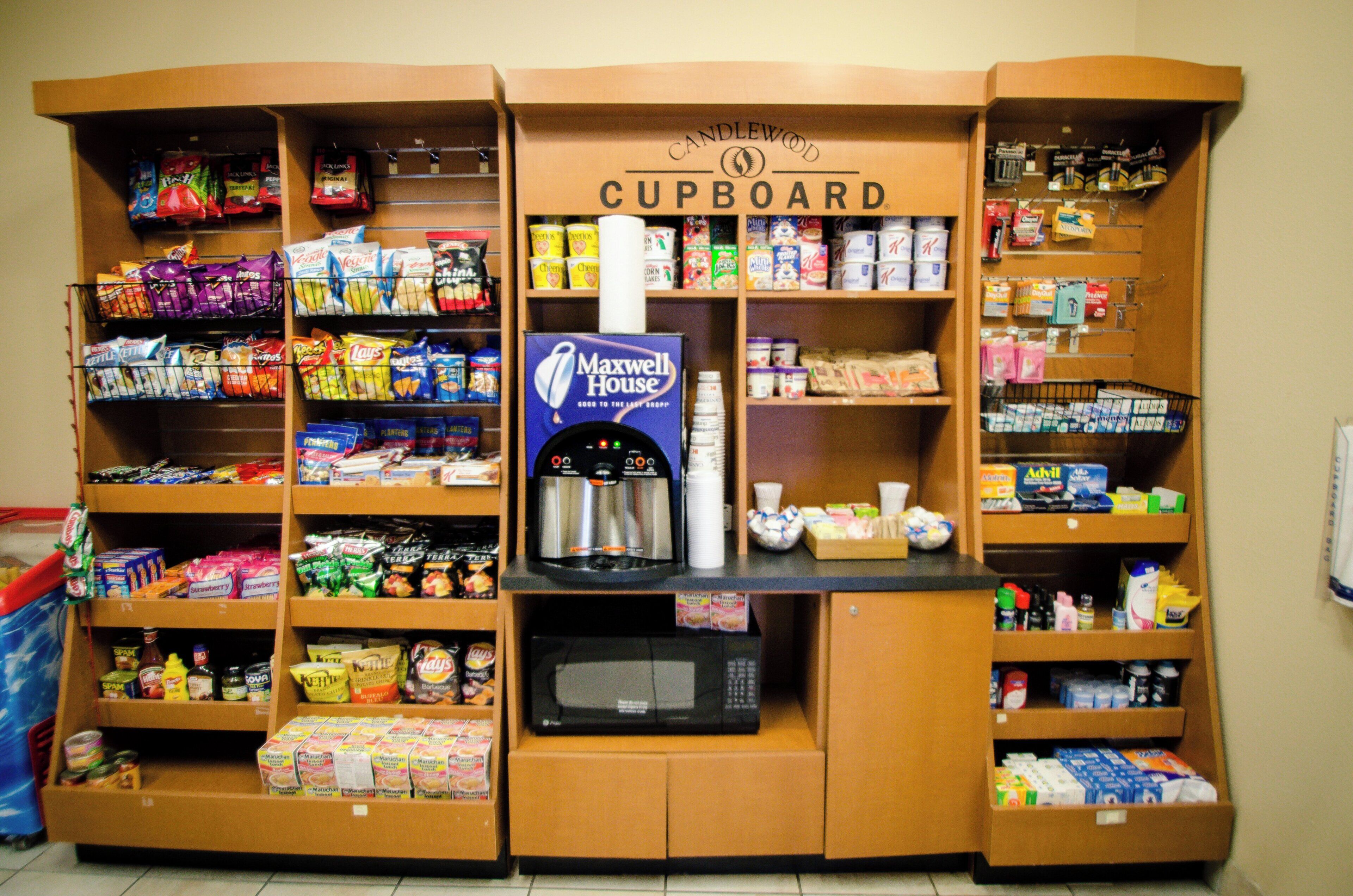 A kitchenette area with a microwave, a coffee machine, and various snacks and beverages.