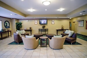 Un hall de hotel con una zona de estar, un televisor y una recepción.