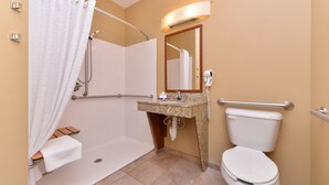A bathroom with a shower, toilet, sink, and a mirror. - Candlewood Suites Williston by IHG (Williston)