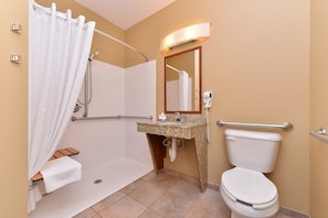 A bathroom with a shower, toilet, sink, and a mirror. - Candlewood Suites Williston by IHG (Williston)