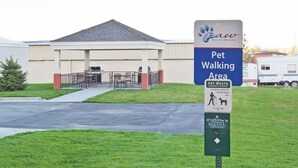 A pet-friendly area sign with a pet waste station and a dog waste bag dispenser. - Candlewood Suites Williston by IHG (Williston)