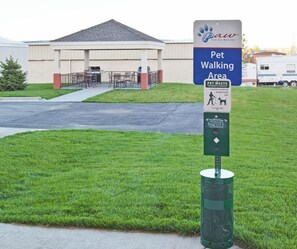 A pet-friendly area sign with a pet waste station and a dog waste bag dispenser. - Candlewood Suites Williston by IHG (Williston)