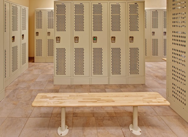 A row of beige lockers with a bench in front. - Candlewood Suites Williston by IHG (Williston)