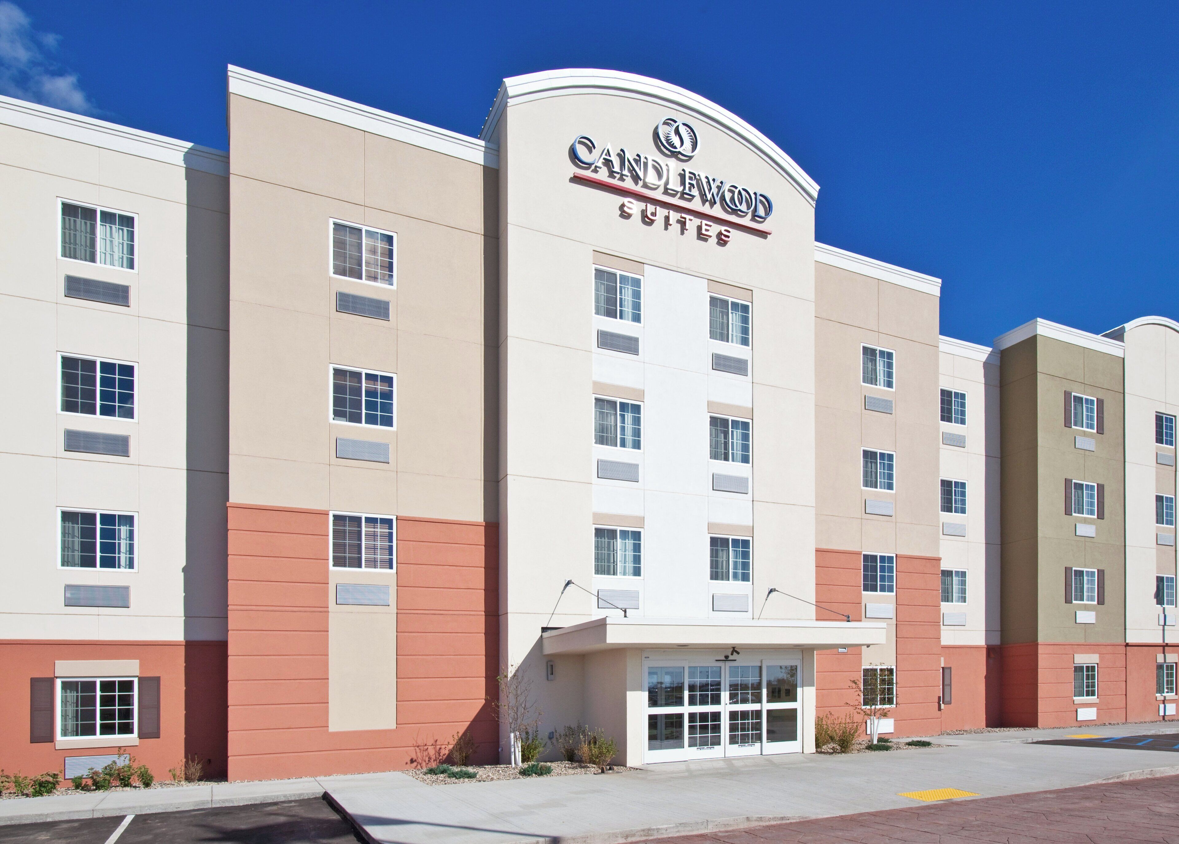 A multi-story hotel with a prominent sign reading 'CANDLEWOOD SUITES.'