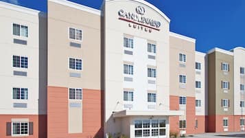 A multi-story hotel with a prominent sign reading 'CANDLEWOOD SUITES.'