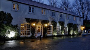 A white building with multiple windows and a door, surrounded by greenery. - Eglinton Arms Hotel, BW Premier Collection (Glasgow)