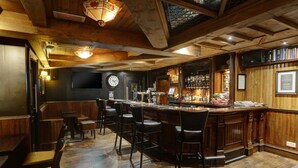 A bar area with wooden furniture, a clock, and a bar stocked with bottles. - Eglinton Arms Hotel, BW Premier Collection (Glasgow)