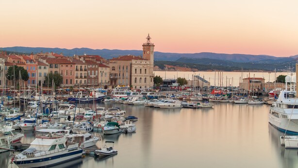 A marina with boats docked, buildings, and a tower in the background. - Appart'City Confort La Ciotat Cote Port (La Ciotat)