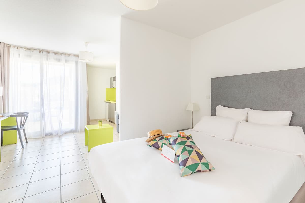 Habitación de hotel con cama, escritorio y silla.
