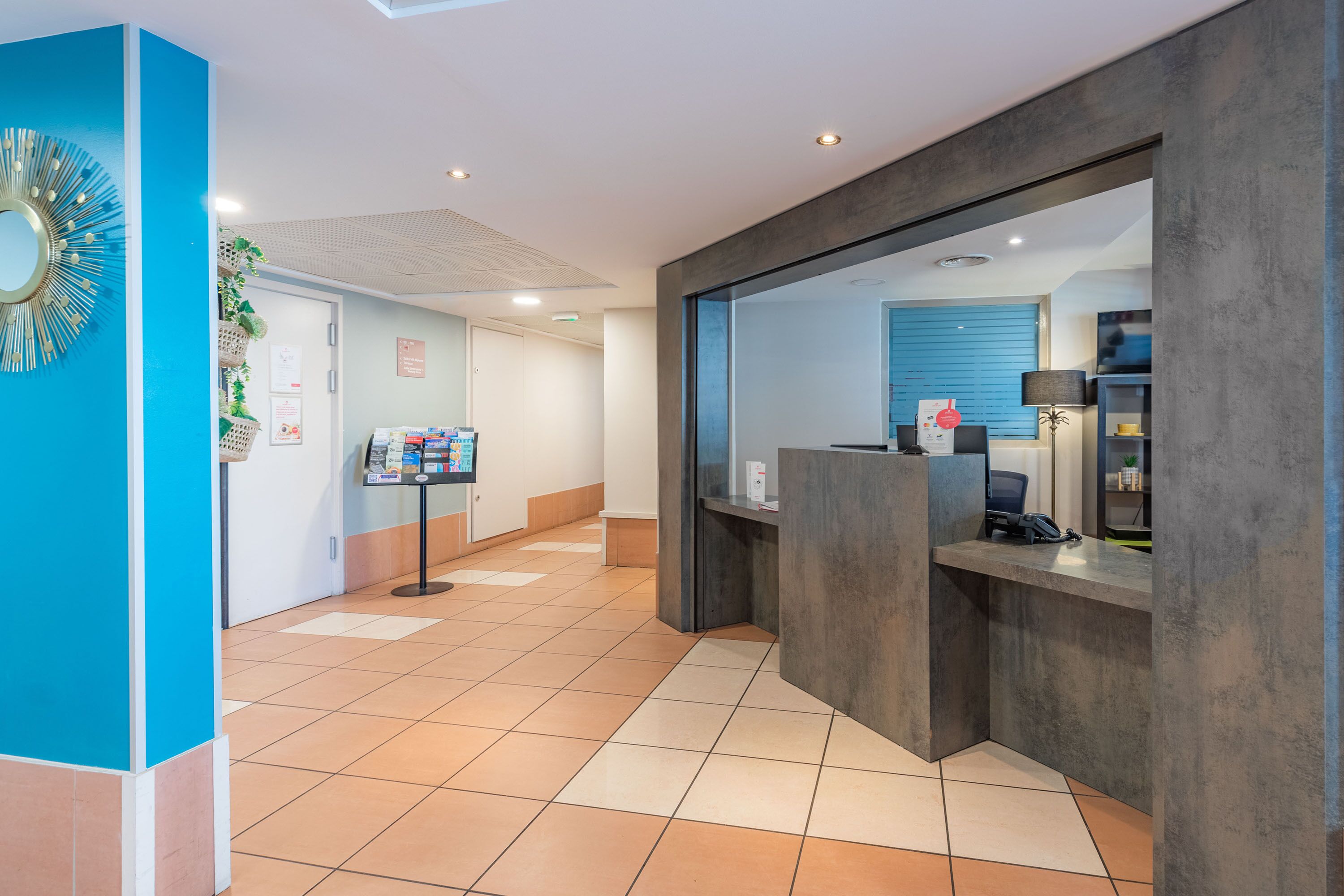 A reception area with a blue accent wall, a reception desk, and a counter.