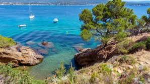 A coastal landscape with clear blue waters, boats, and rocky terrain. - Appart'City Confort La Ciotat Cote Port (La Ciotat)