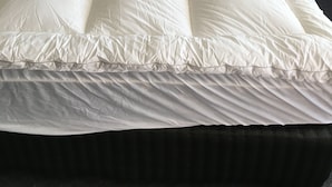 A bed with a wooden headboard, white bedding, and two bedside tables with lamps. - Airport Whyalla Motel (Whyalla Norrie)