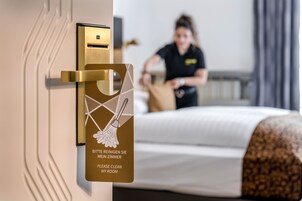 Porta de quarto de hotel com aviso para limpeza do quarto.