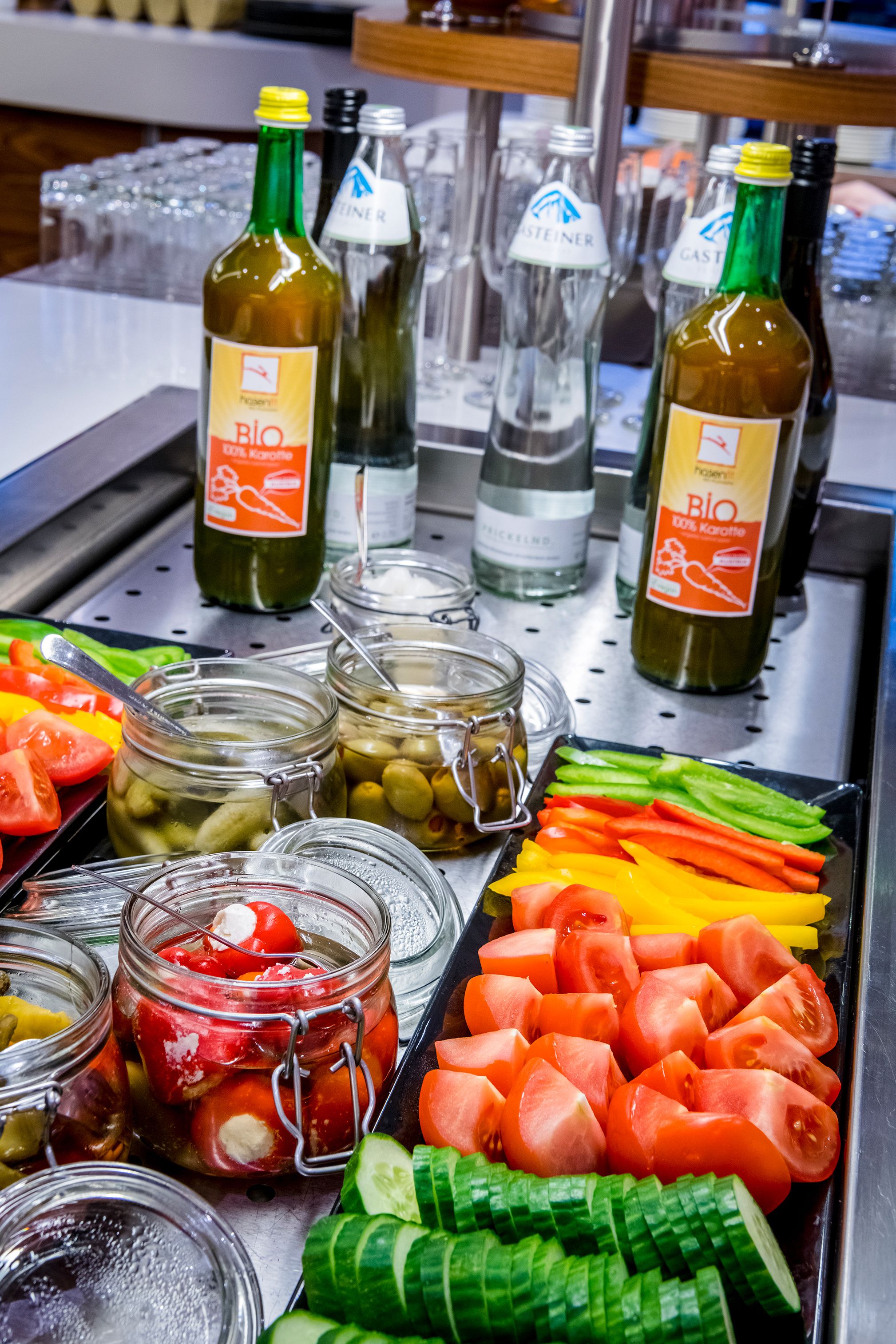 A buffet with various food items and bottles of wine.